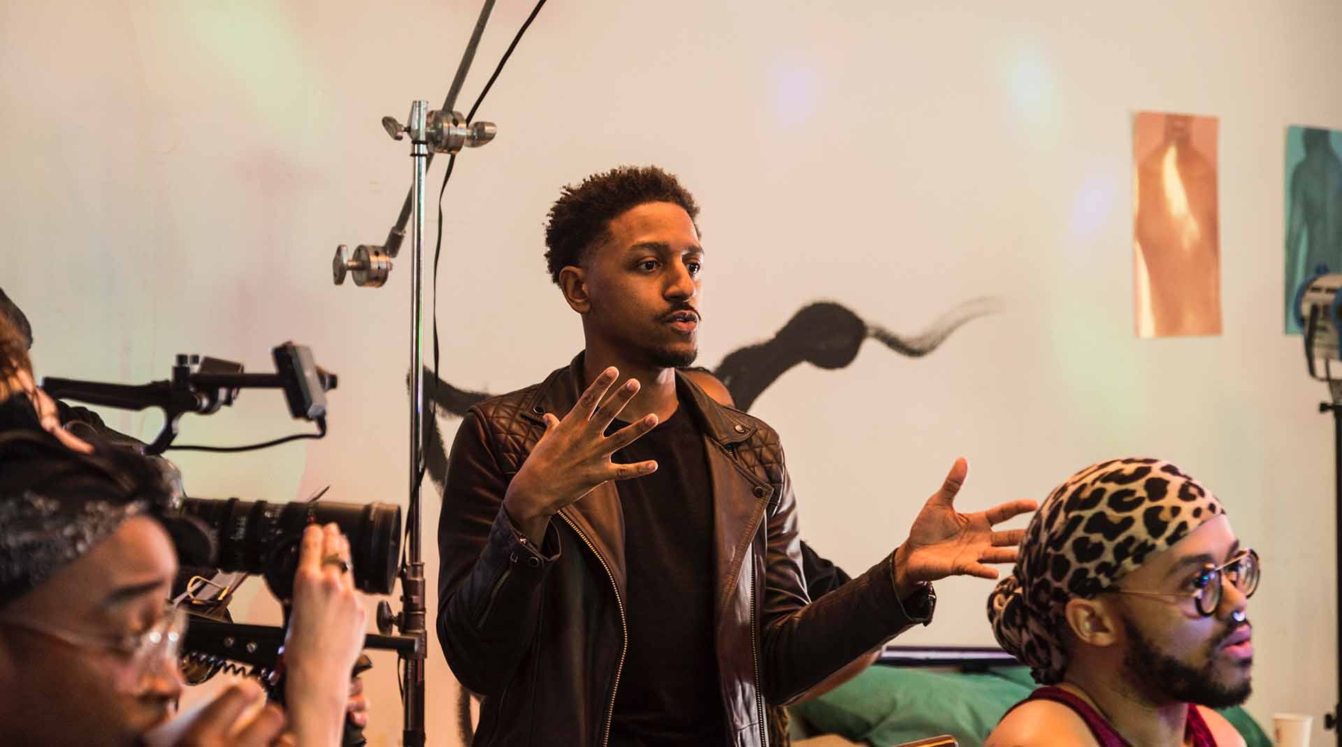 Aymar Jean Christian speaking while on set in a video production (Photo Credit: Jackie RIvas)