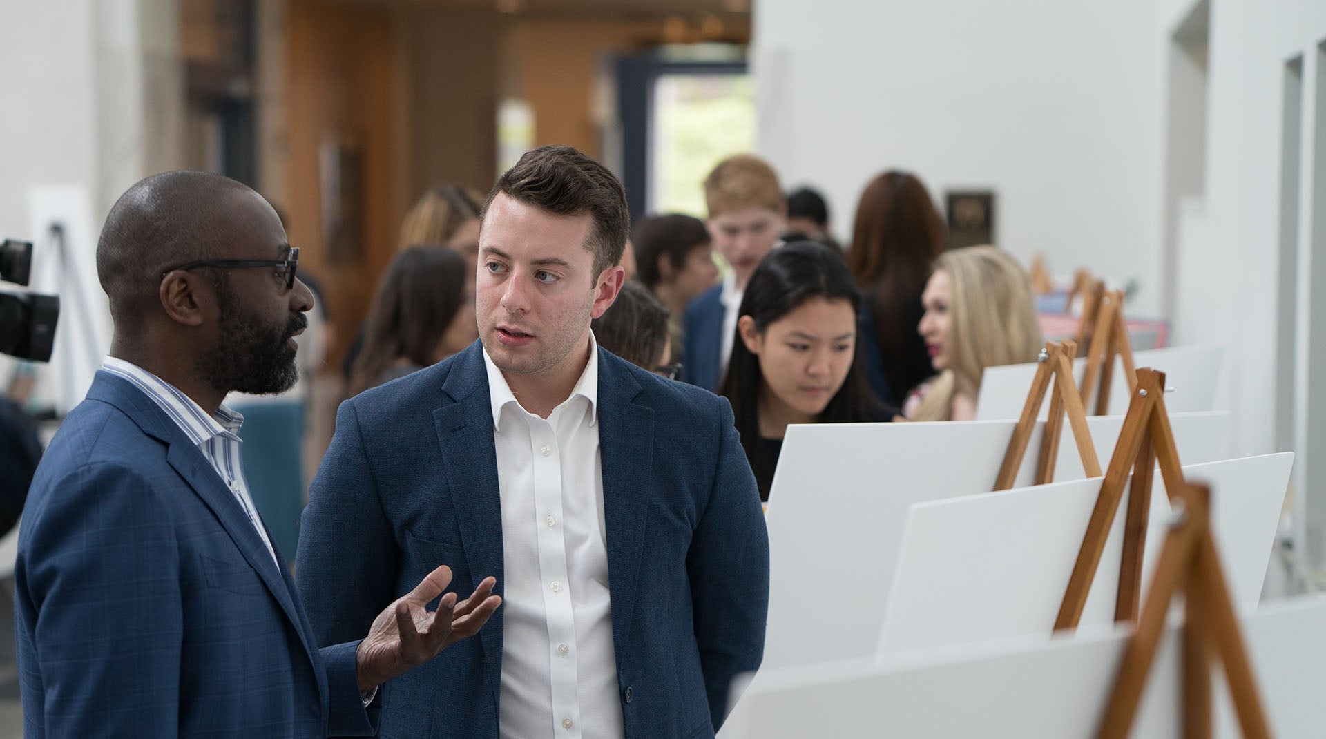 Dean Jackson talking to a ComPS student at a poster presentation session